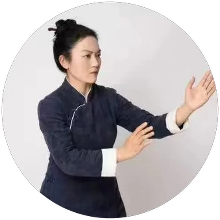 Lixin in a taiji posture against a plain grey background