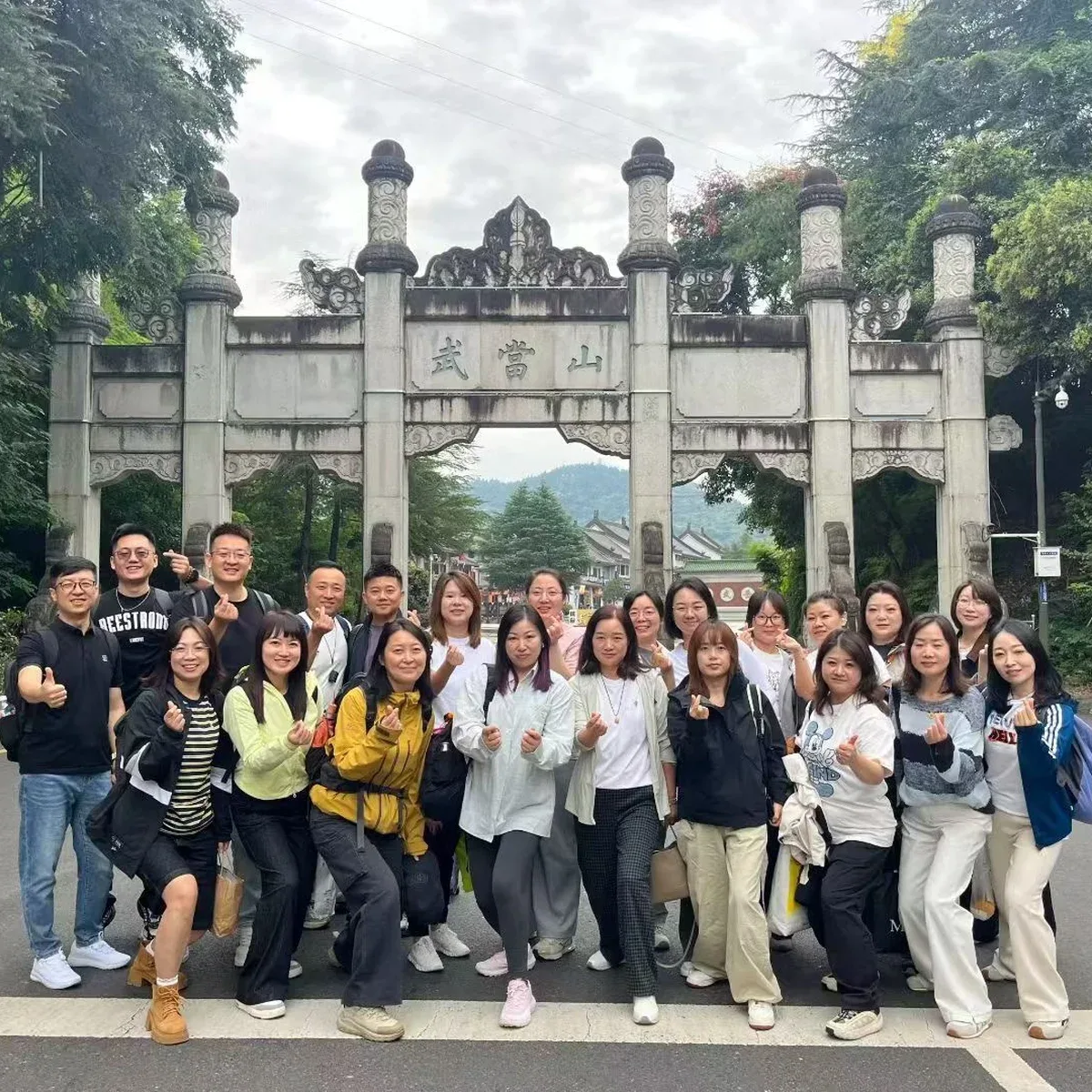 Un groupe de visiteurs se rassemble sous la porte de pierre au pied de la montagne de Wudang.