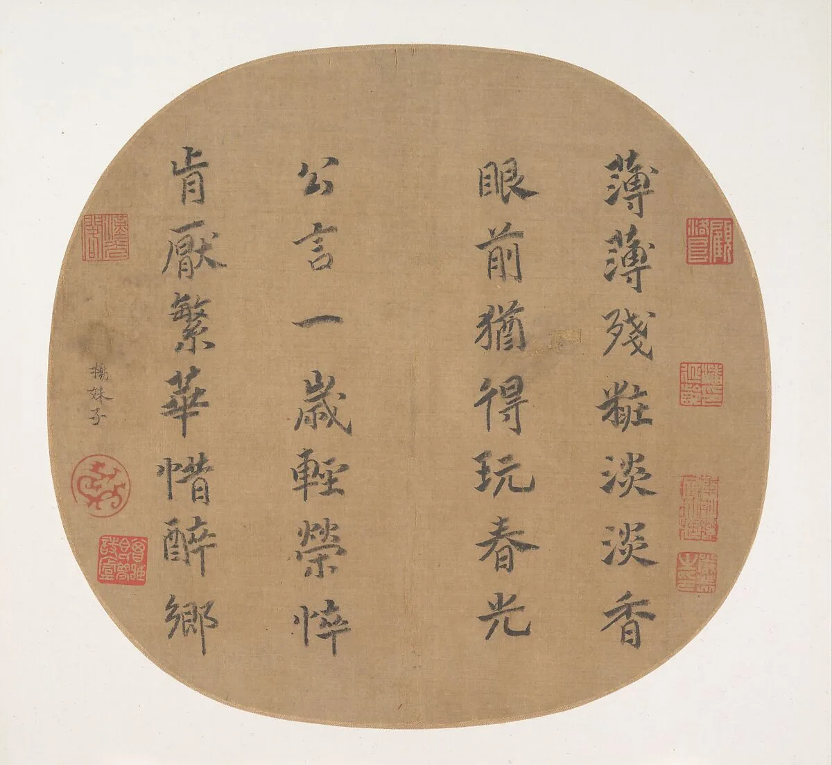 Quatre colonnes de calligraphie chinoise sur une feuille d’éventail arrondie en soie, avec de petites empreintes rouges.