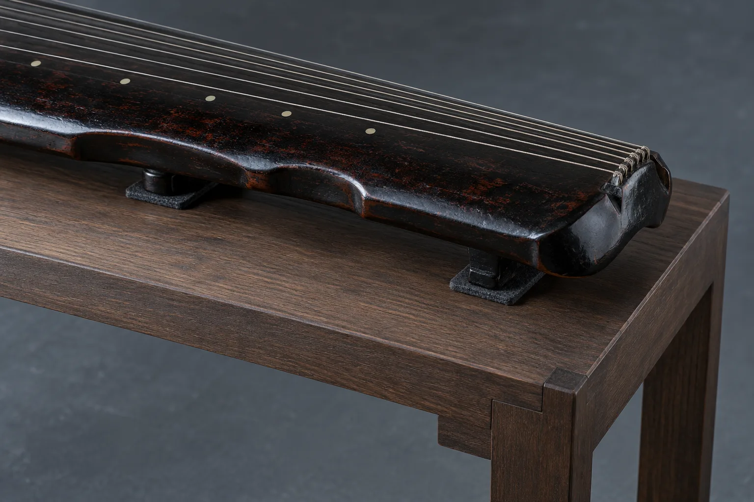 Photographie conceptuelle générée par IA, en gros plan, d’un guqin fictif à sept cordes reposant sur de petites cales au-dessus d’une table en bois sobre