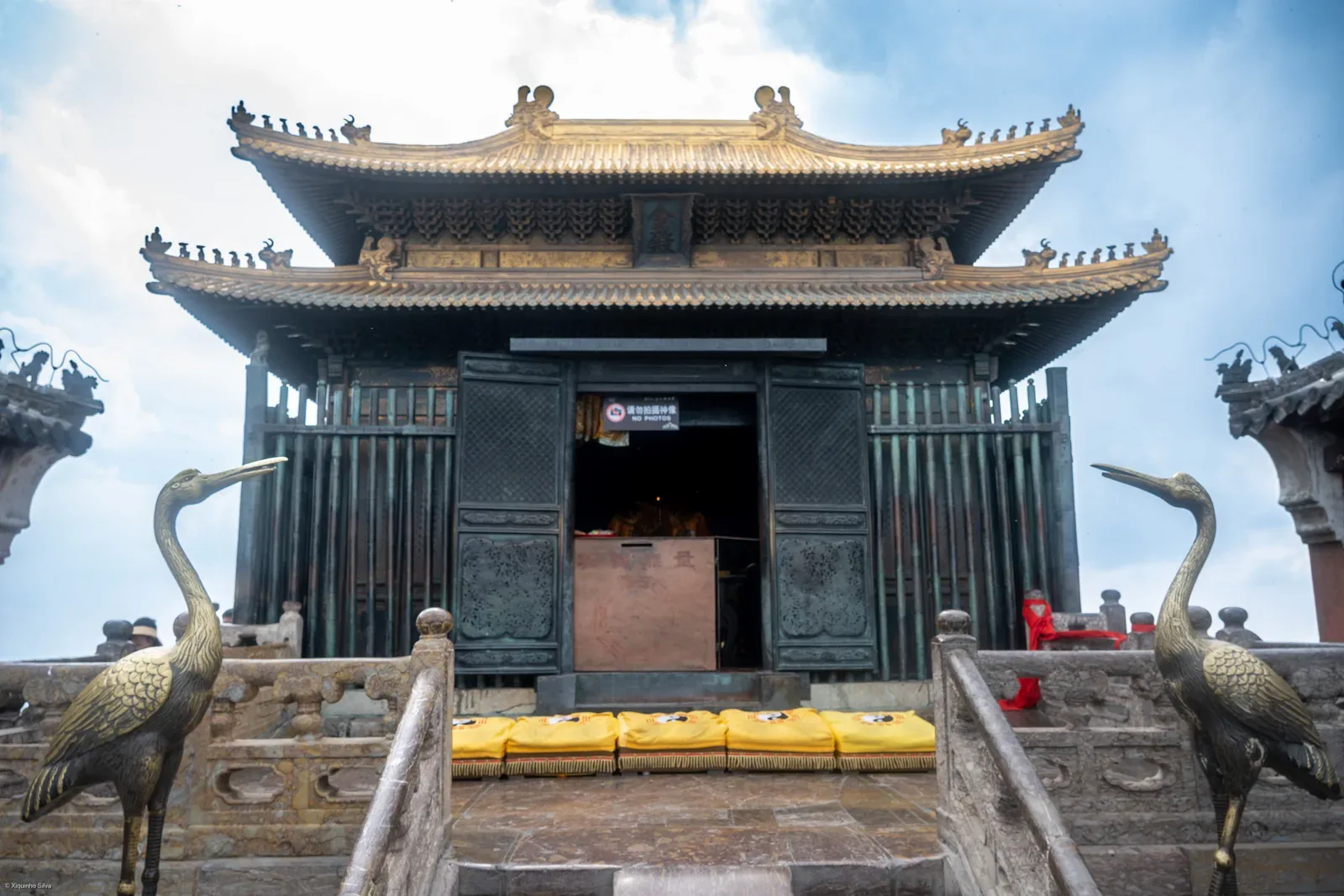 La Salle d’or en bronze au sommet du Wudang, à double toit, précédée d’une terrasse de pierre où se dressent deux grues de bronze et des coussins jaunes.