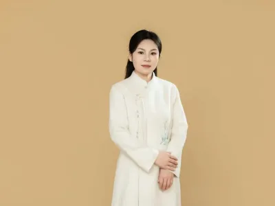 Chongmin in a white embroidered robe, hands folded, against a plain tan background