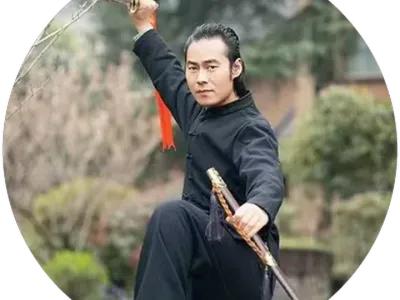 Chongtian holding a sword in a raised, one-legged stance in a garden